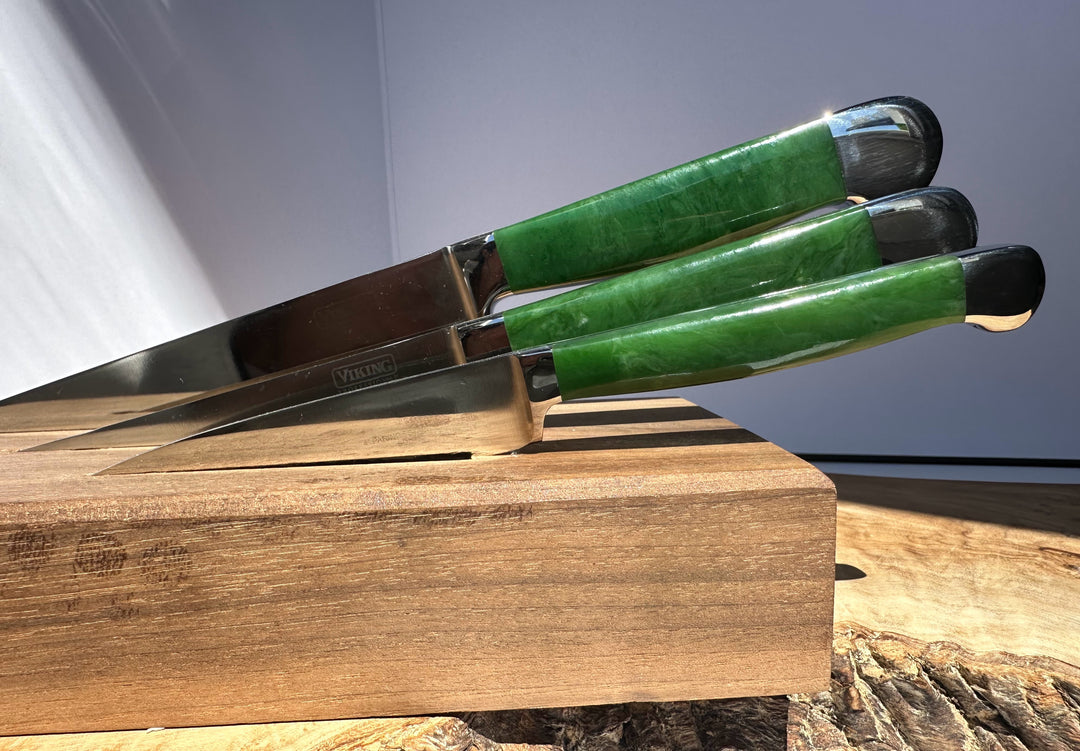 Set of knives with green jade handles on a wooden block