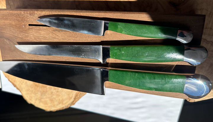Set of knives with green handles on a wooden block
