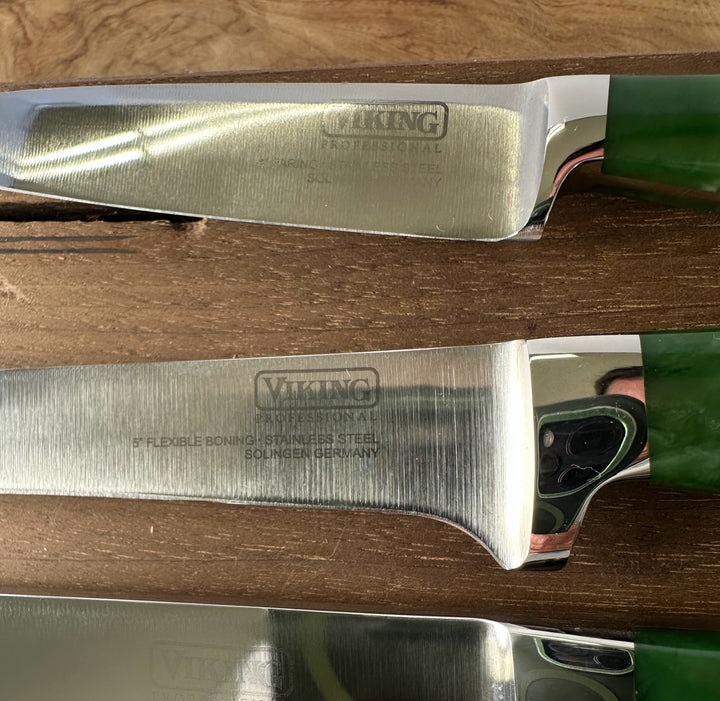 Two Viking brand knives on a wooden surface