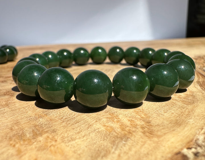 Green jade beads on a wooden surface