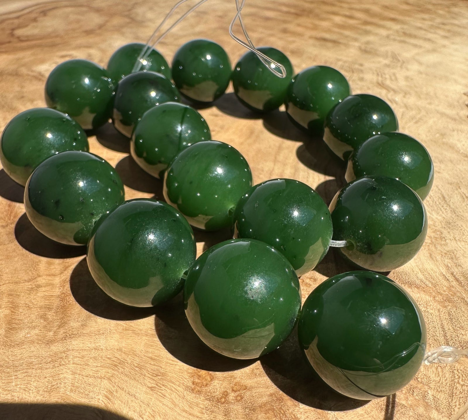 Green jade beads on a wooden surface
