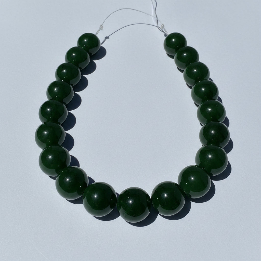 Green jade bead necklace on a white background