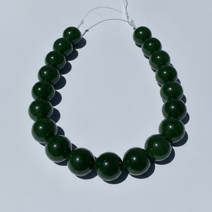 Green jade bead necklace on a white background