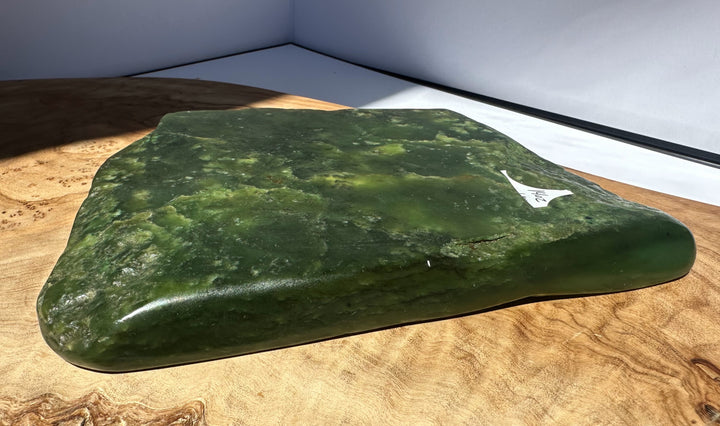 Green stone on a wooden surface with a white background