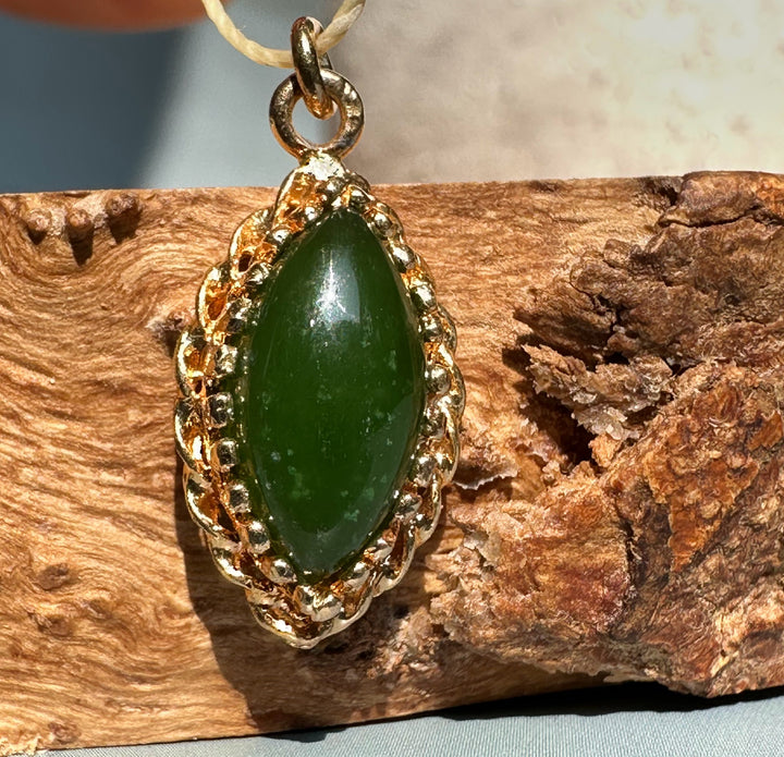 Vintage jade marquise pendant with an ornate gold bezel