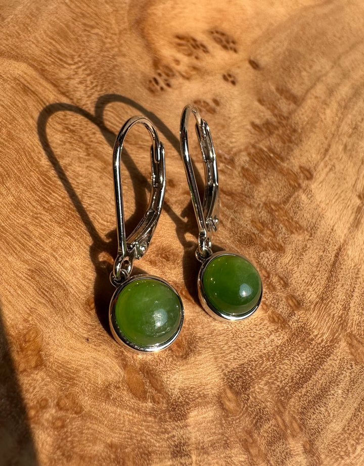 Two green jade round 6mm stones in silver bezels on leverback hooks.