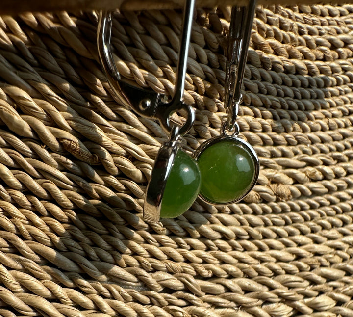 Close-up of jade round leverback earrings showing green stones set in silver bezels.