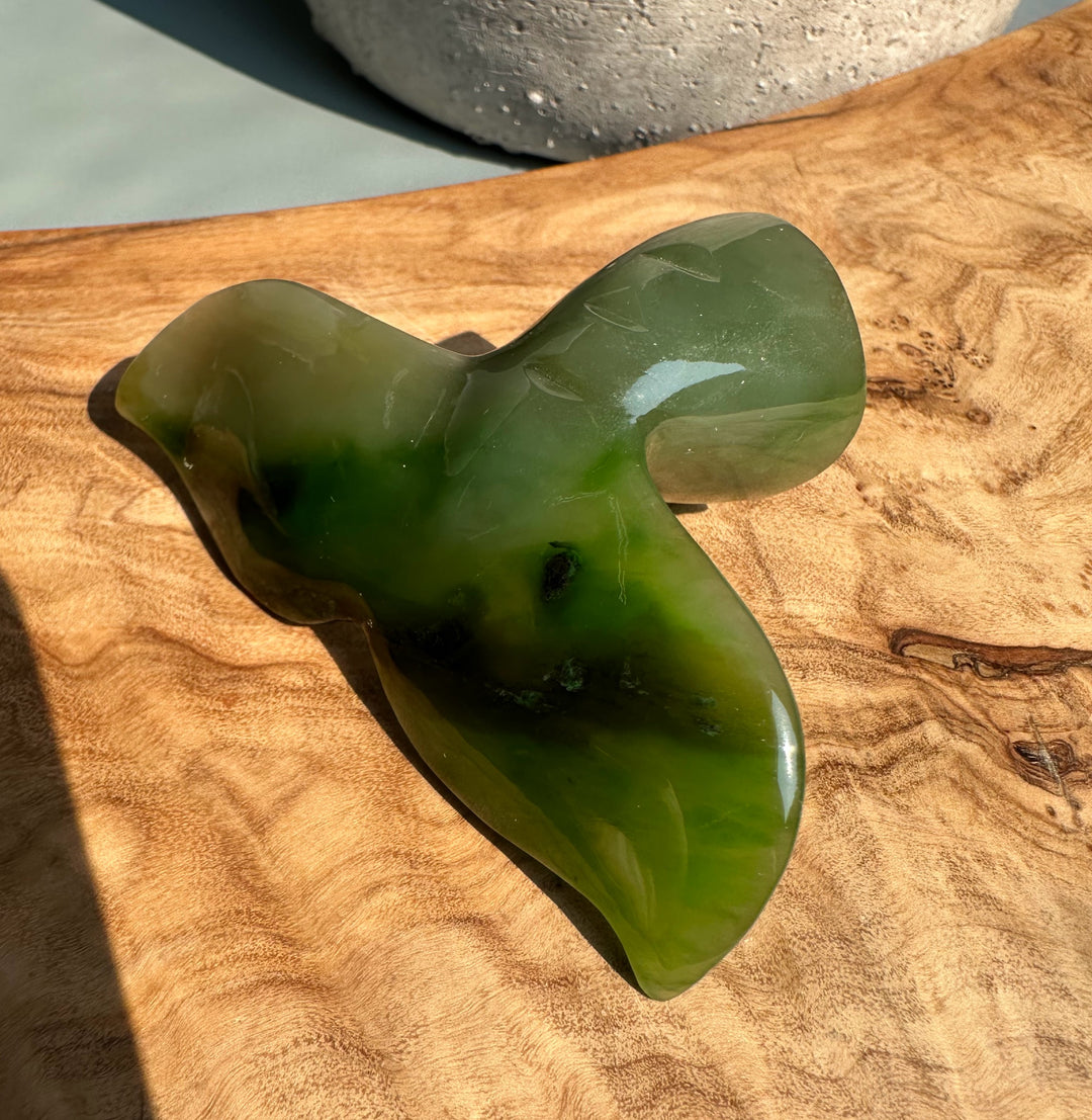 Green Polar Jade whale drawer pull viewed from above showing its curved shape and glossy finish on wood.