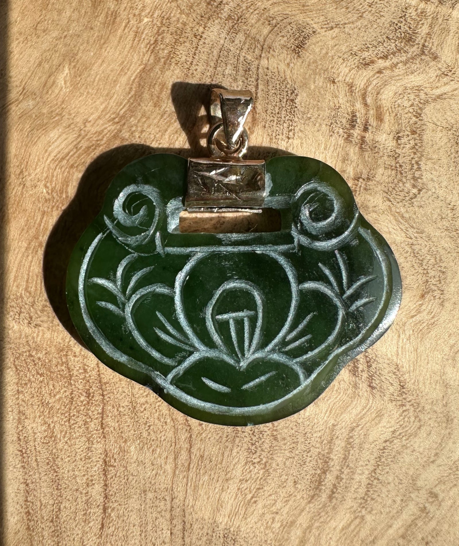 Vintage green jade pendant with a flower carving and a silver bail.