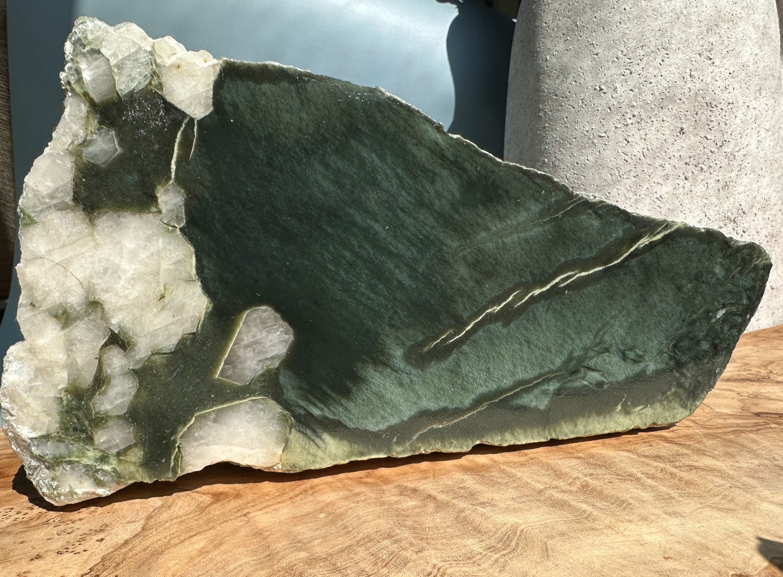 Wyoming rough jade slab with dark green interior and white quartz crystals along one edge