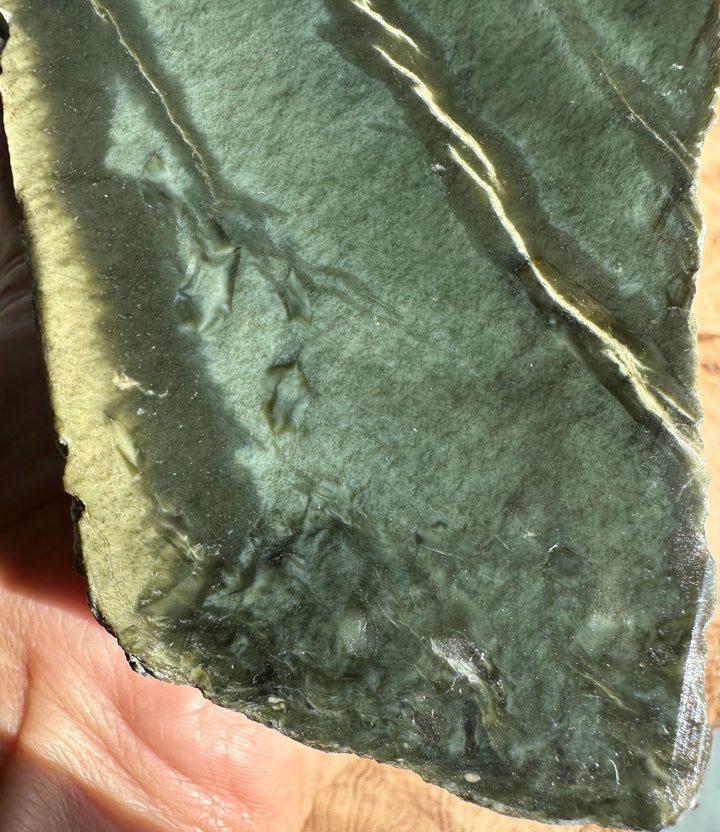 Close-up of dark green Wyoming Rough Jade slab showing color variation and pale edge.