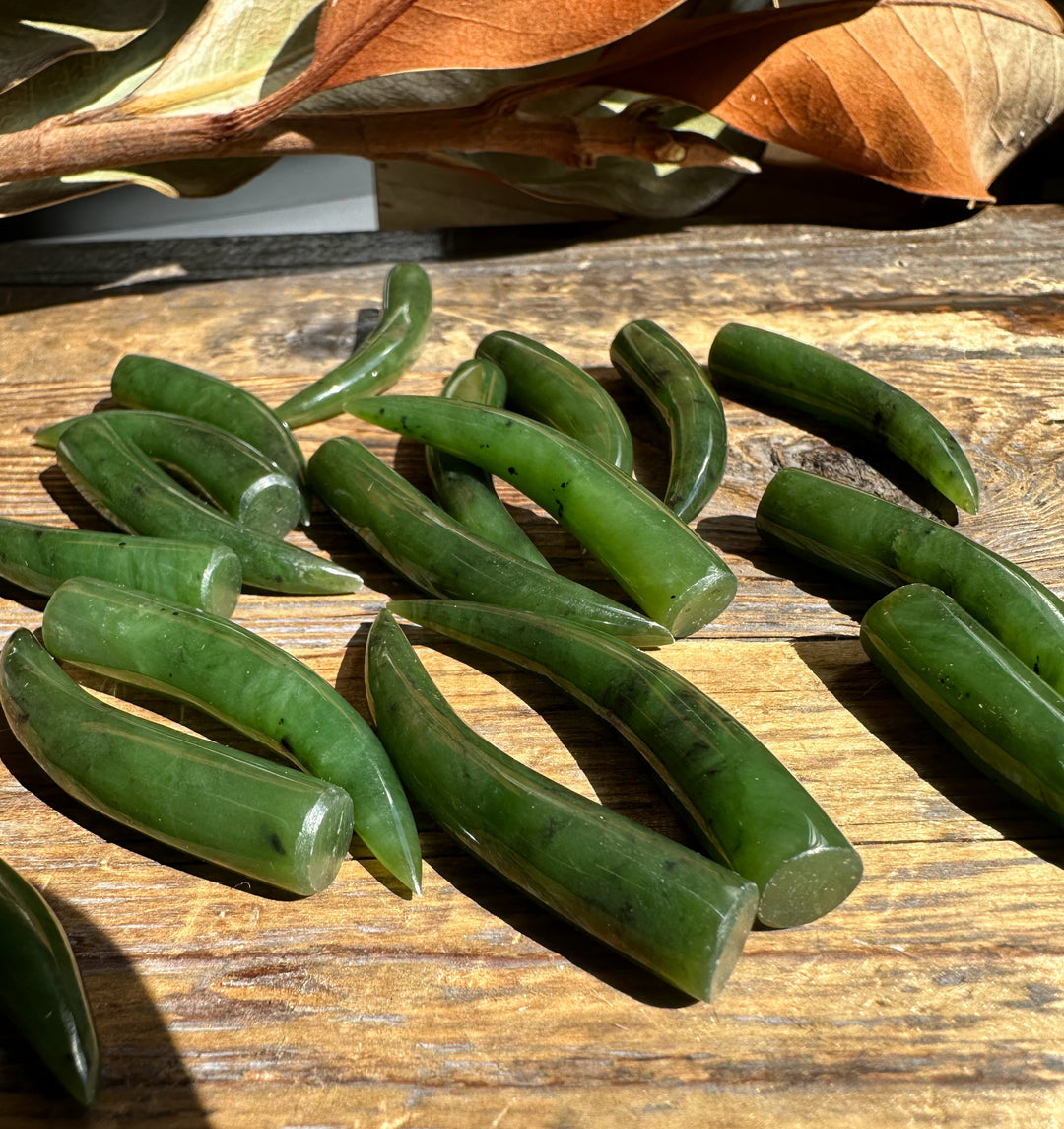 Green jade talons scattered across sunlit weathered wood