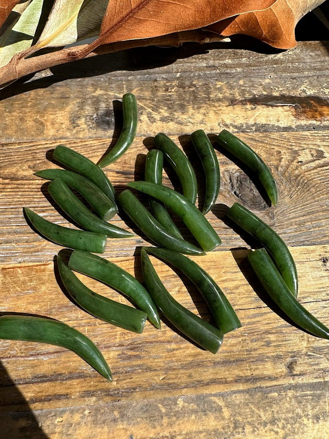 Group of green jade talon pieces on a weathered wooden surface