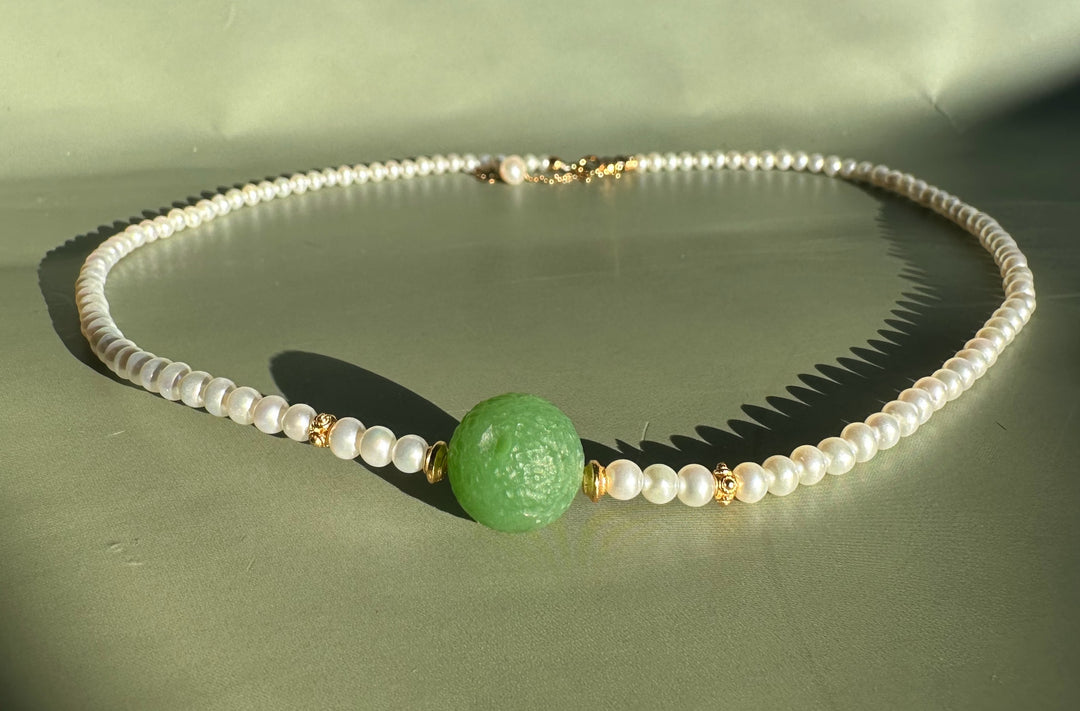 Close-up of Siberian and Pearl Necklace with the green centerpiece bead and pearl strand accented by gold spacers.