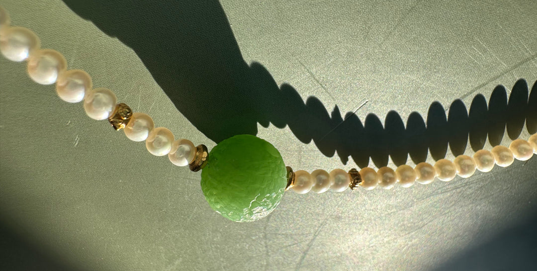 Close up of Siberian and Pearl Necklace showing white pearls gold spacers and a textured green central bead