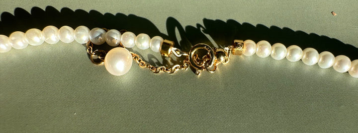 Siberian and Pearl Necklace featuring a large central pearl charm and gold clasp