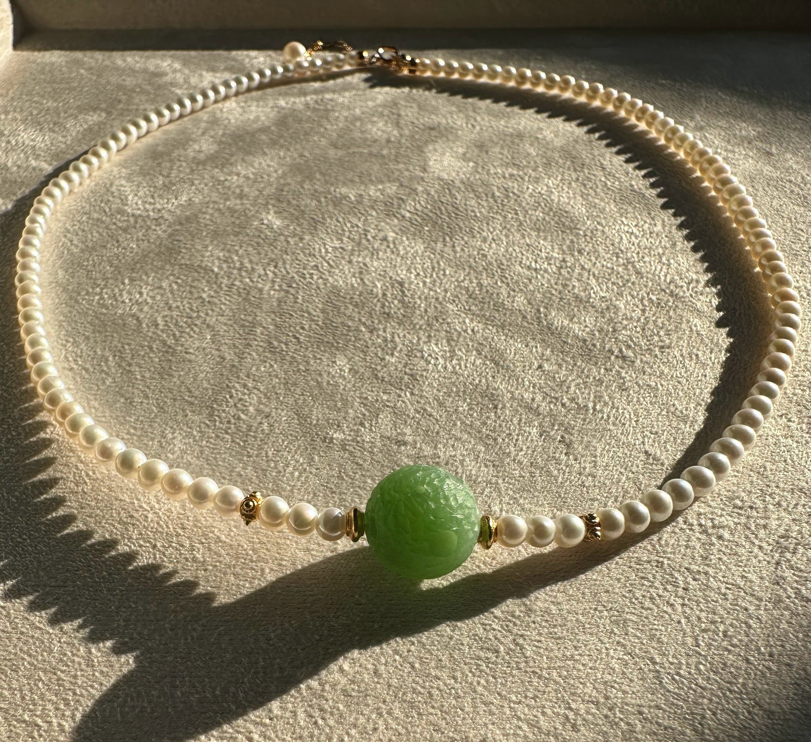 Siberian and Pearl Necklace with white pearls and a large green carved centerpiece bead with gold accents