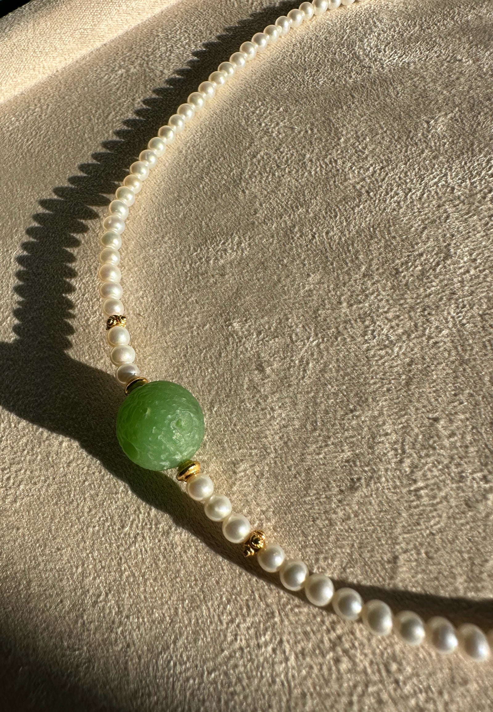 Siberian and Pearl Necklace featuring a green centerpiece bead with white pearl strand and gold spacers.