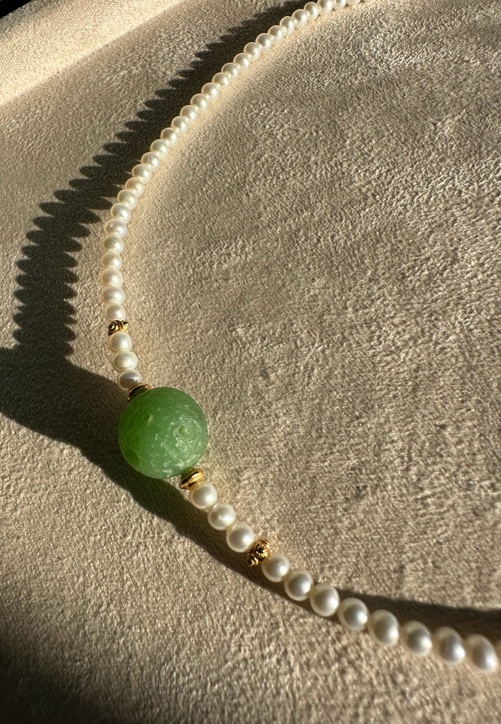 Siberian and Pearl Necklace featuring a green centerpiece bead with white pearl strand and gold spacers.