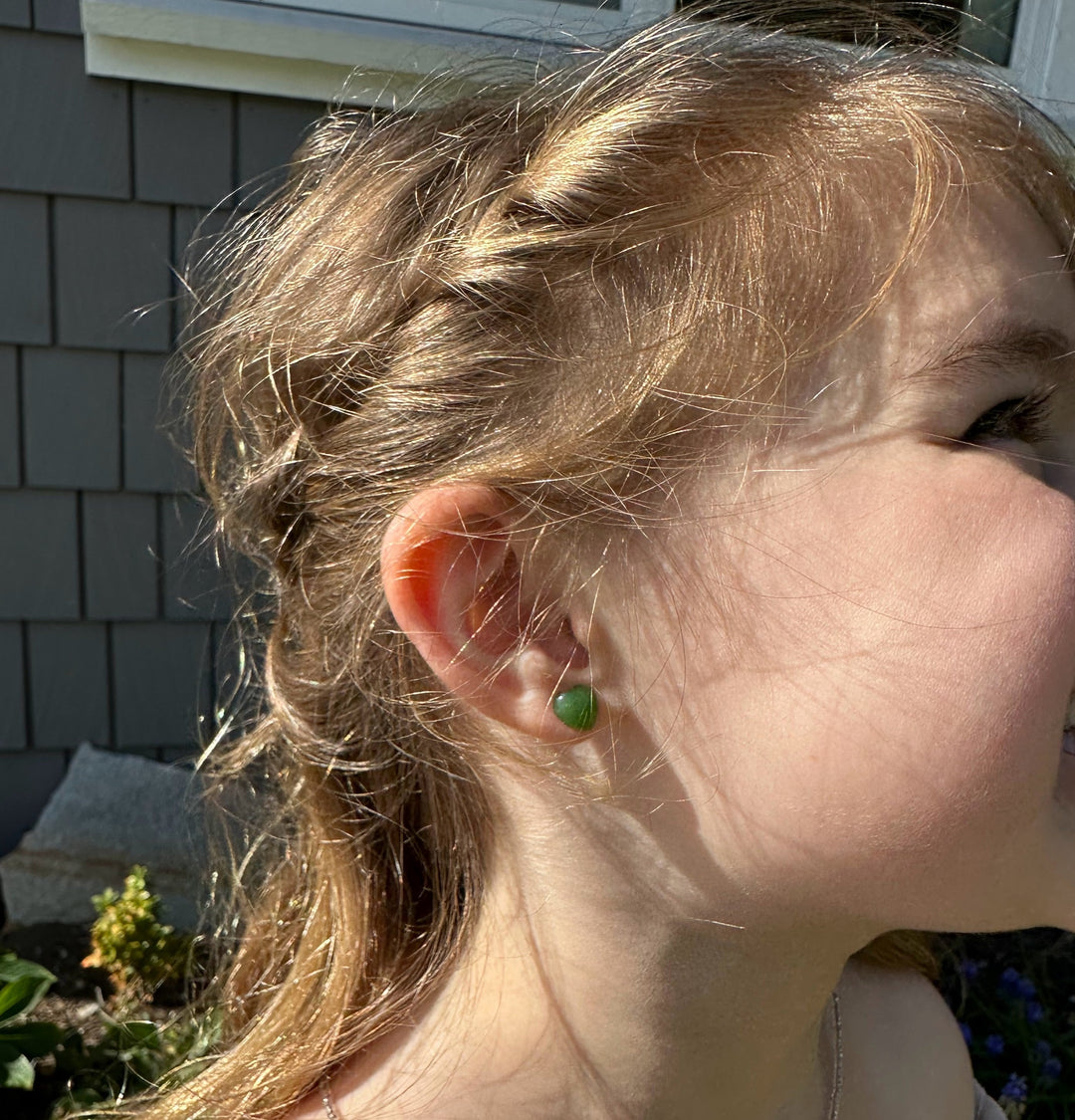 Green jade heart stud earring worn on a woman&