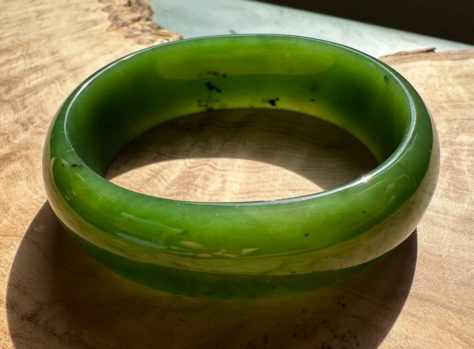 A+ Canadian Jade Oval Bangle 52.5mm bright green jade viewed from above with a glossy finish