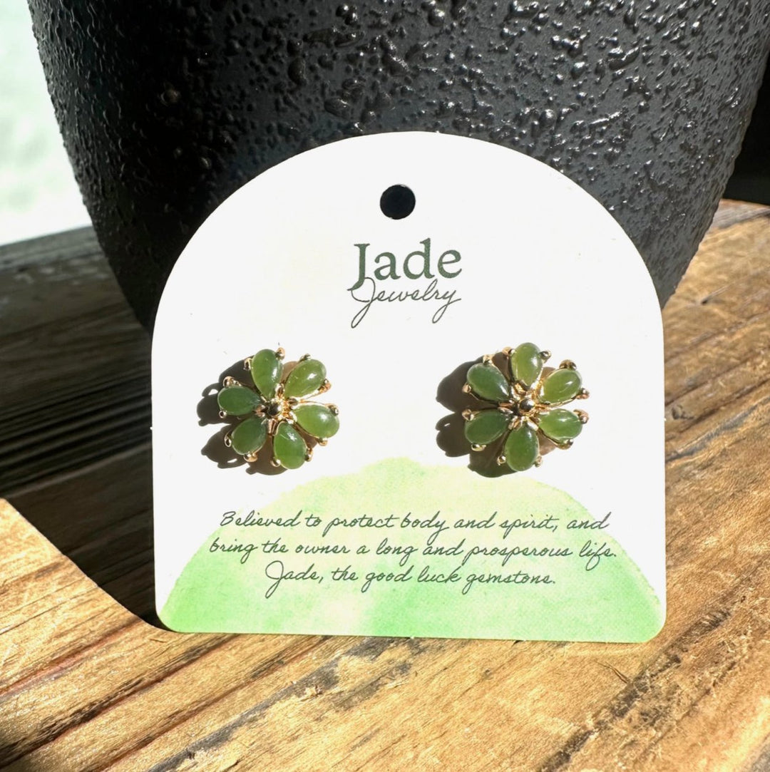 Pair of green jade flower stud earrings on white Jade Jewelry card