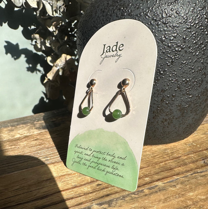 Jade Jewelry card displaying two gold-tone teardrop earrings with green jade beads