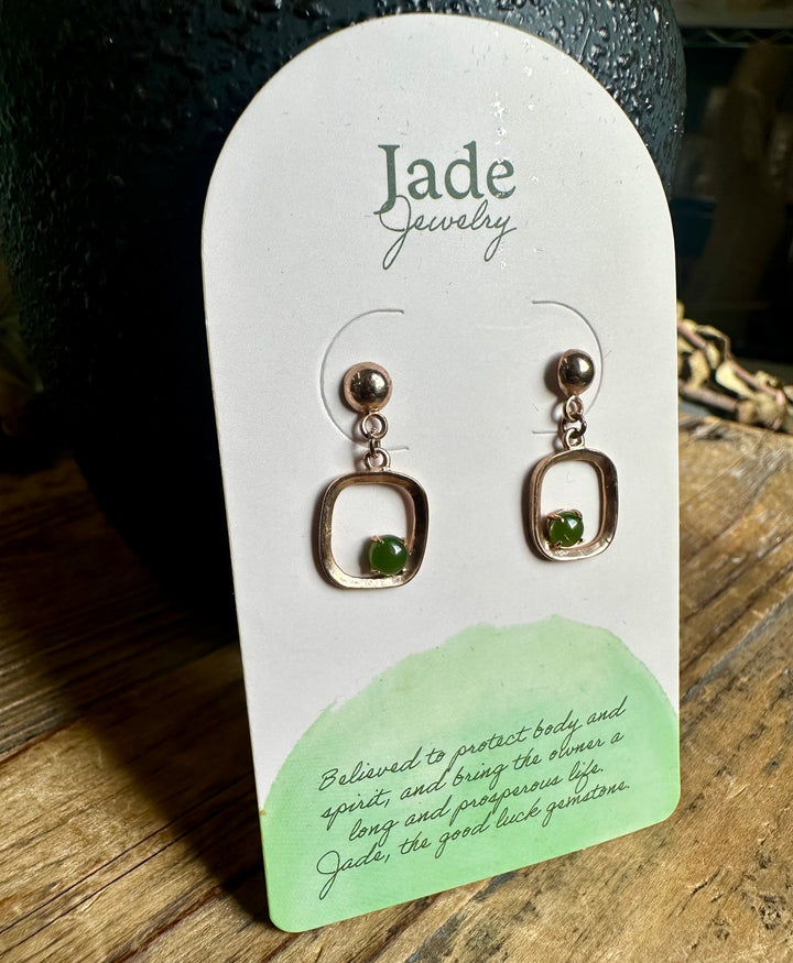 Vintage jade earrings with square open frames and green beads on a white display card
