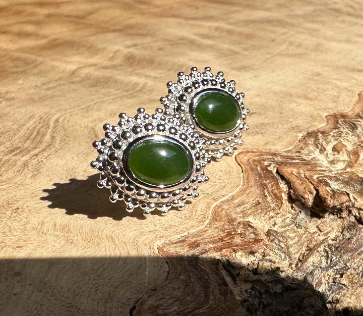 Canadian Jade and Silver Earrings featuring two oval green jade stones with a beaded silver halo.