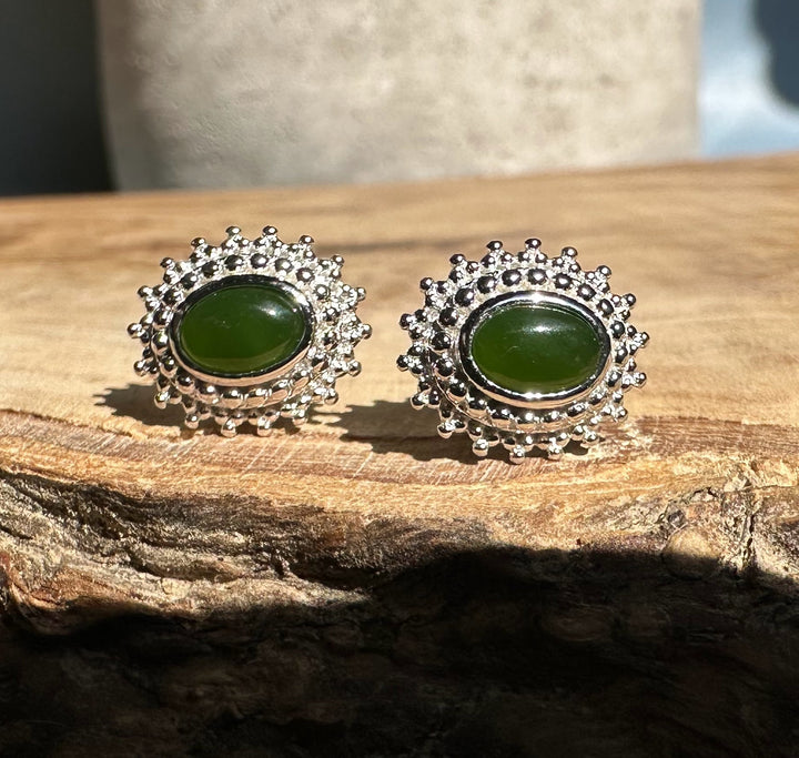 Green jade and silver stud earrings with a beaded sunburst halo.