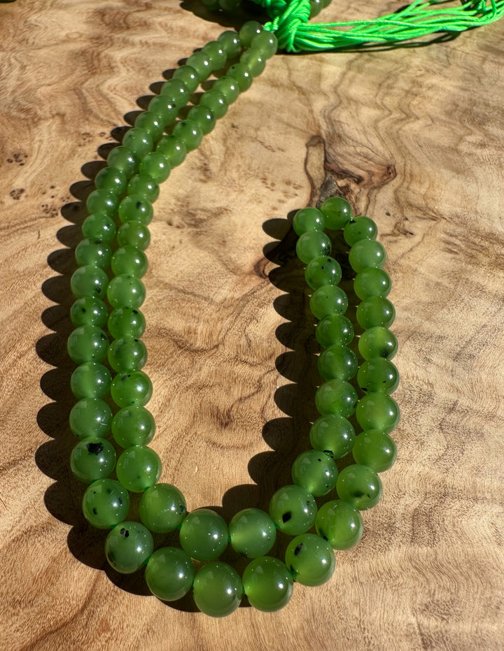 Six millimeter green round beads on a neon green cord, unstrung