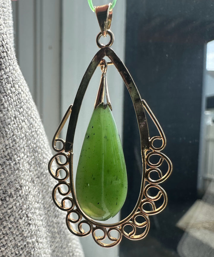 Vintage nephrite jade teardrop pendant in a dark copper scroll frame with a top bail