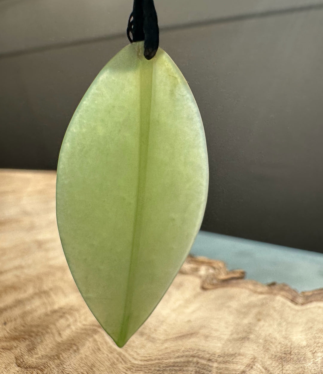 Pale green Siberian Jade Leaf Pendant suspended from a black cord