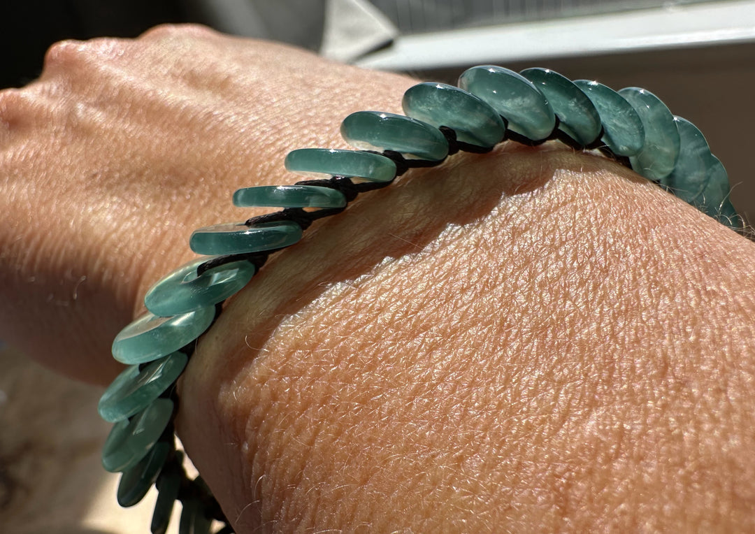 Guatemalan Jadeite PI Round Bracelet worn on the wrist with glossy teal green beads.