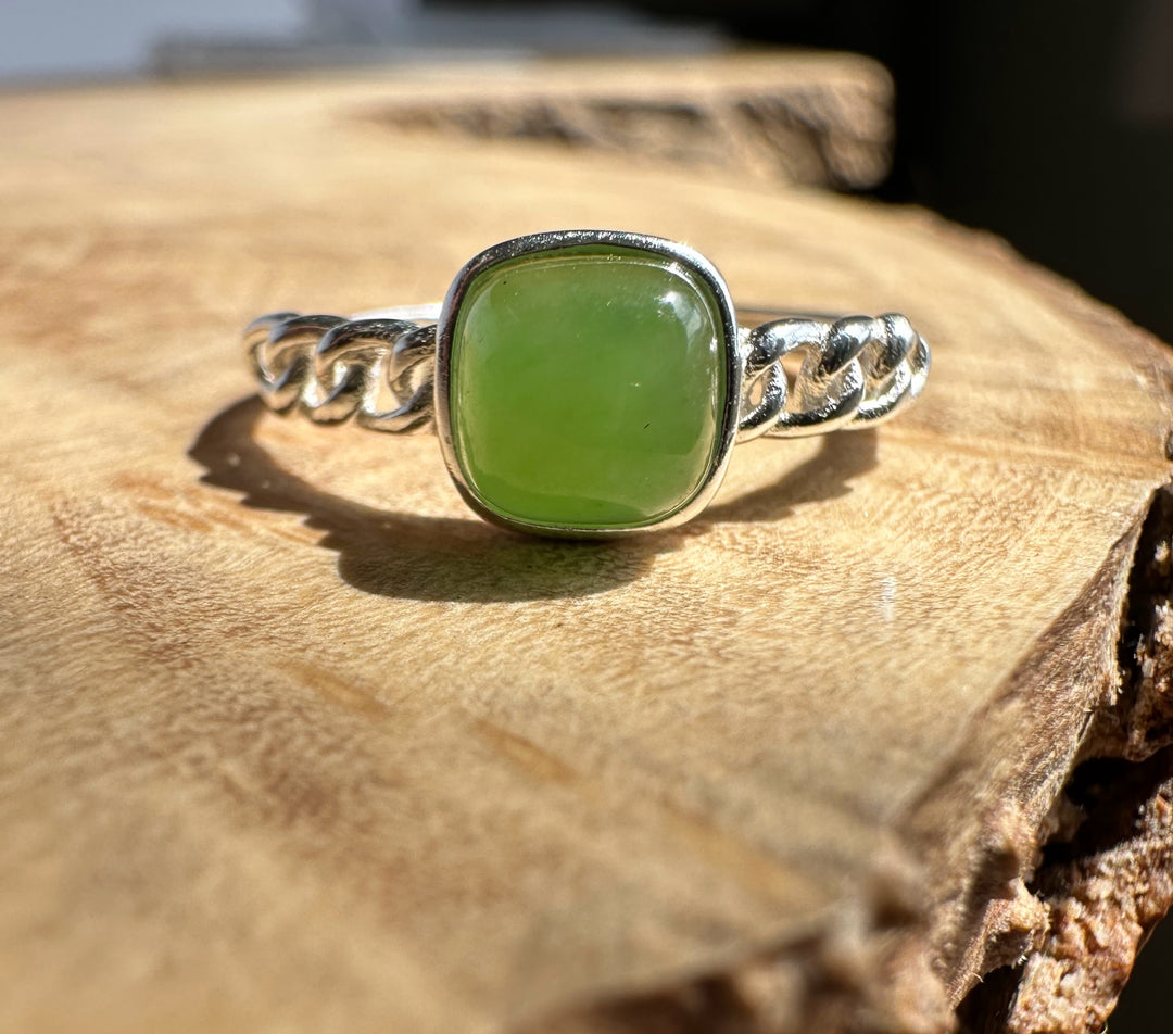 Green jade silver ring on wooden base