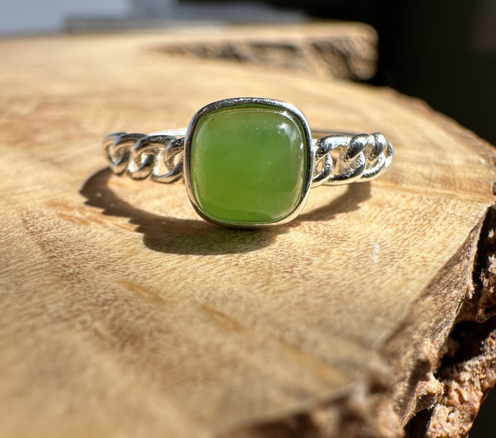 Green jade silver ring on wooden base