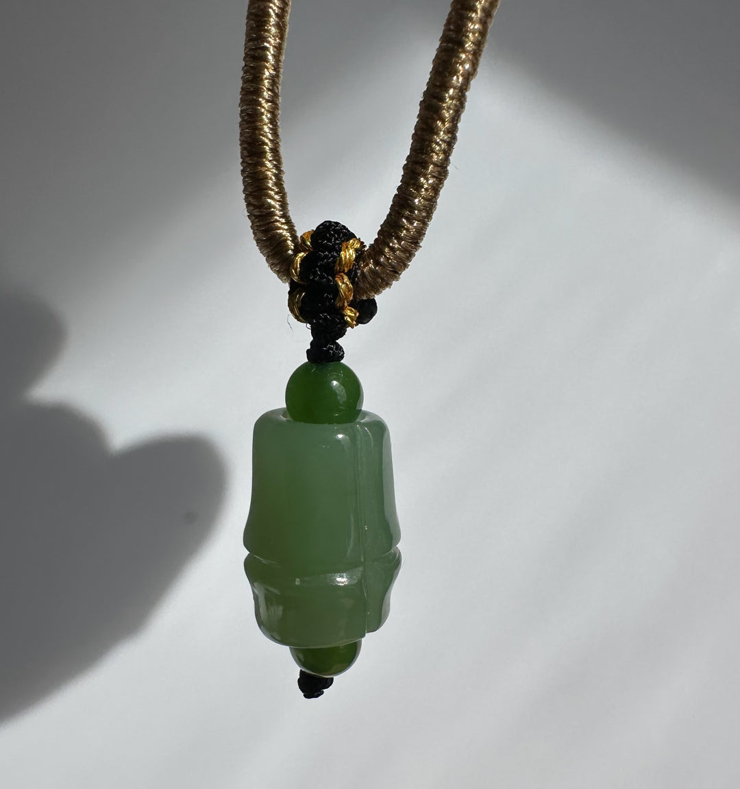 Siberian Jade Pendant 11mm on a brown braided cord with a black and gold knot