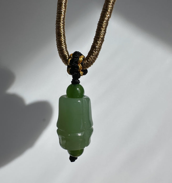 Siberian Jade Pendant 11mm on a brown braided cord with a black and gold knot