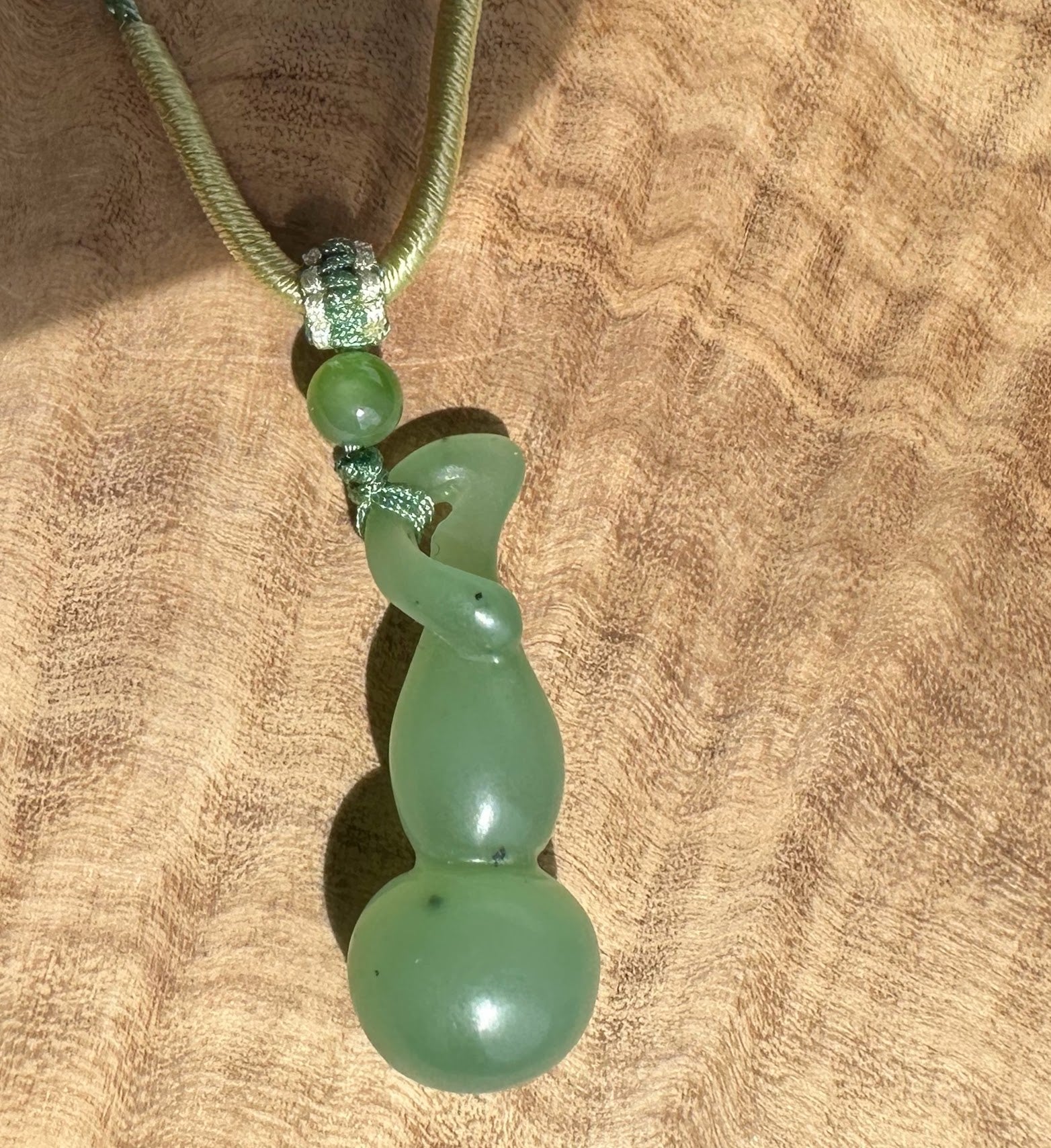Siberian nephrite Hulu pendant with a coiled green drop and matching beads on a braided green cord