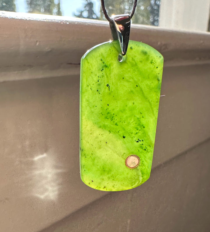 Lime green rectangular dog tag pendant with a small copper dot near the bottom, hanging from a silver bail on a cord.