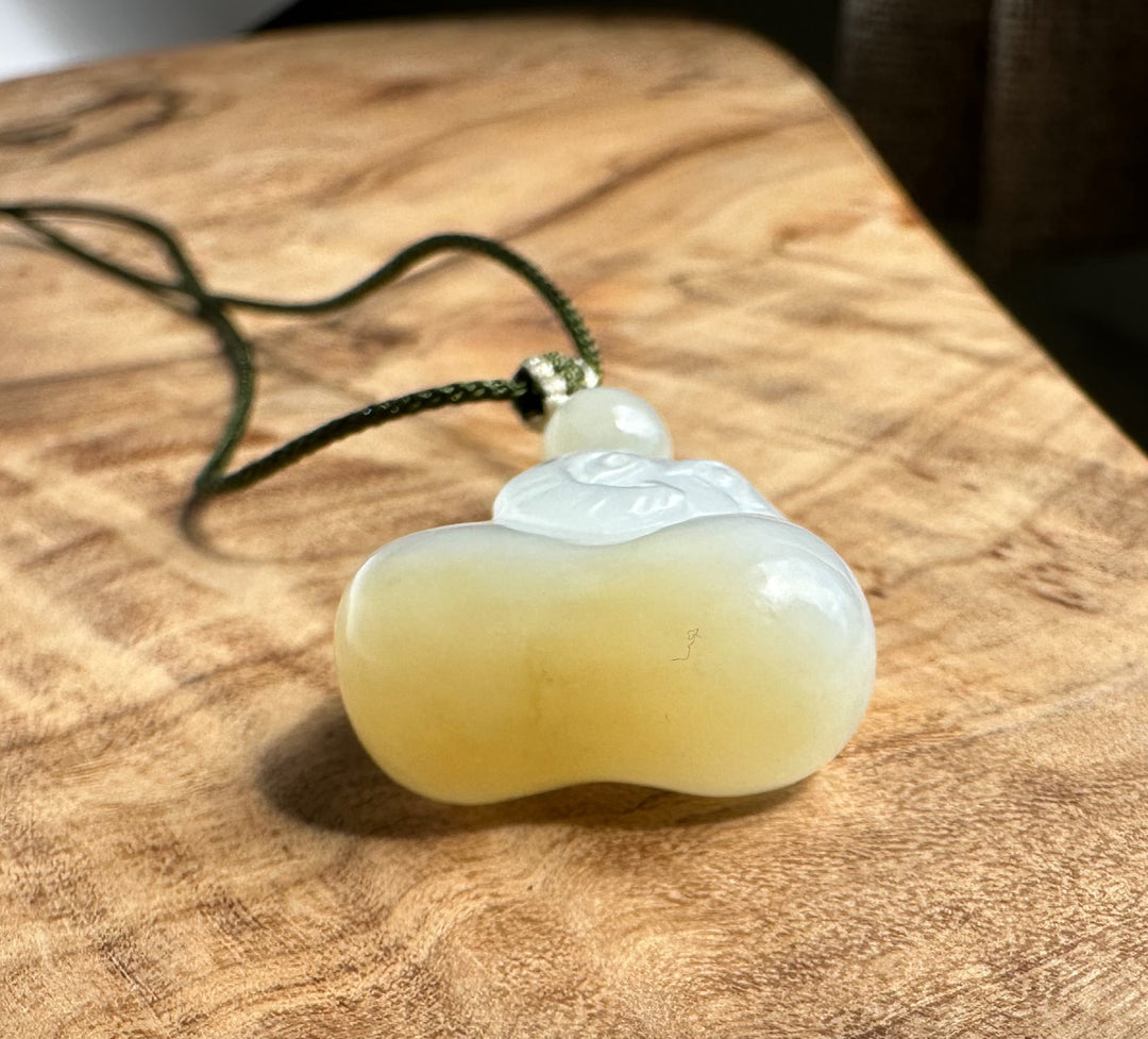 bottom side of a jade pendant on a wooden surface