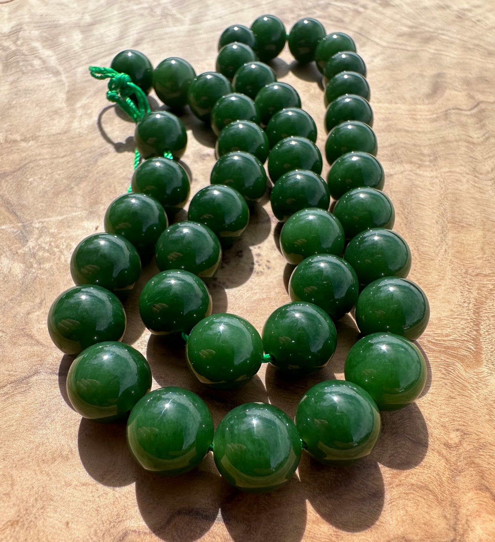 Rich dark green siberian beads on wooden base