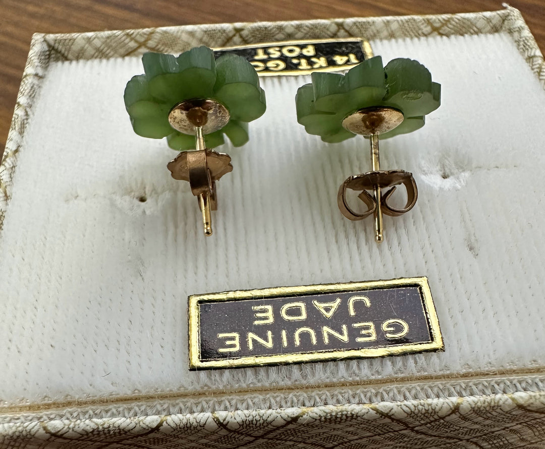 Shamrock shaped green jade stud earrings with gold posts on a display box.