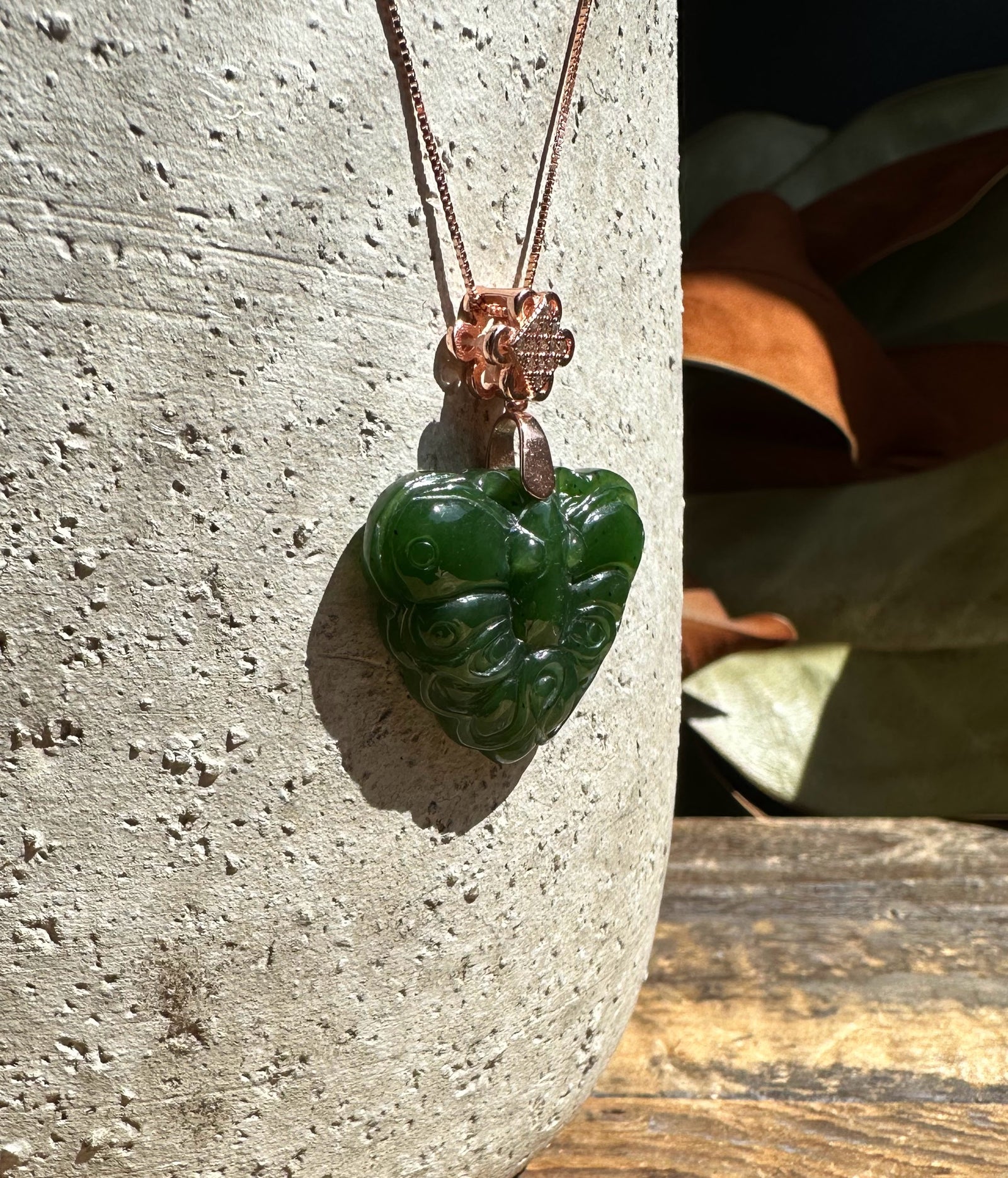 Dark green nephrite jade butterfly pendant on a rose gold chain with a floral bail