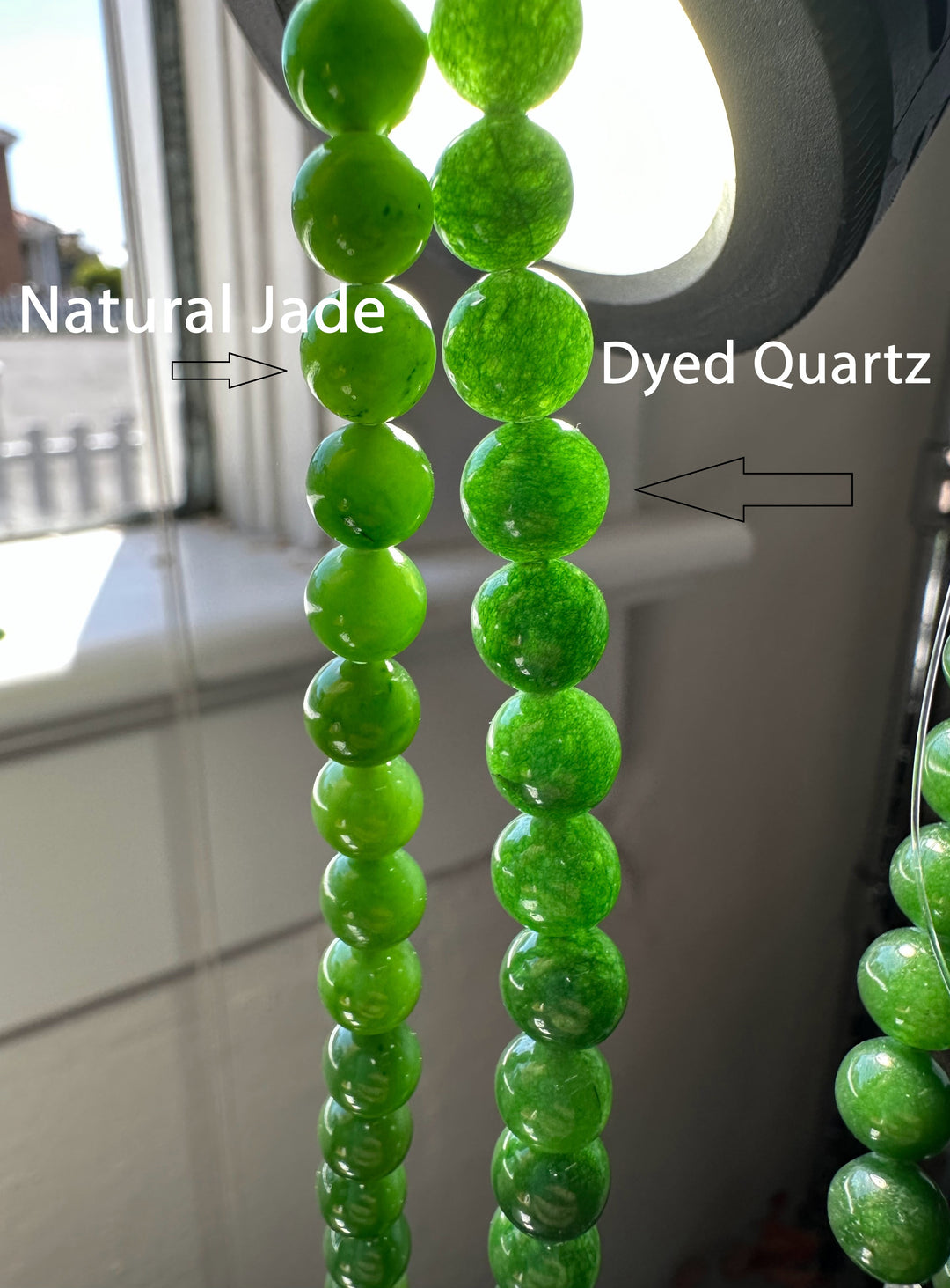 Two 7mm bead strands under bright light showing natural jade on the left and dyed quartz on the right.