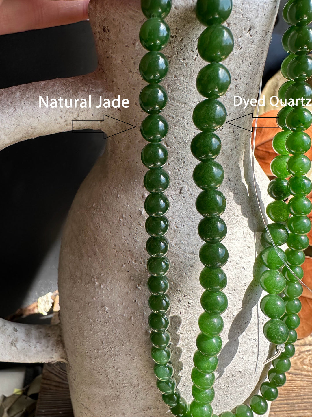 Natural grade nephrite jade beads 7mm unstrung 16 inch strand draped over a textured vase.