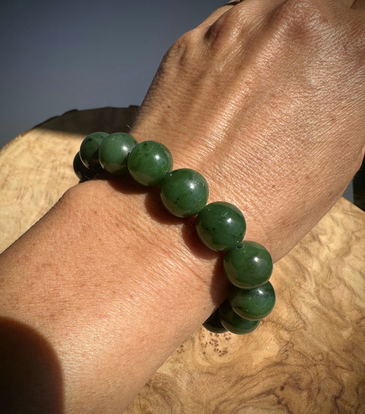 A close-up of a green beaded bracelet worn on a person&