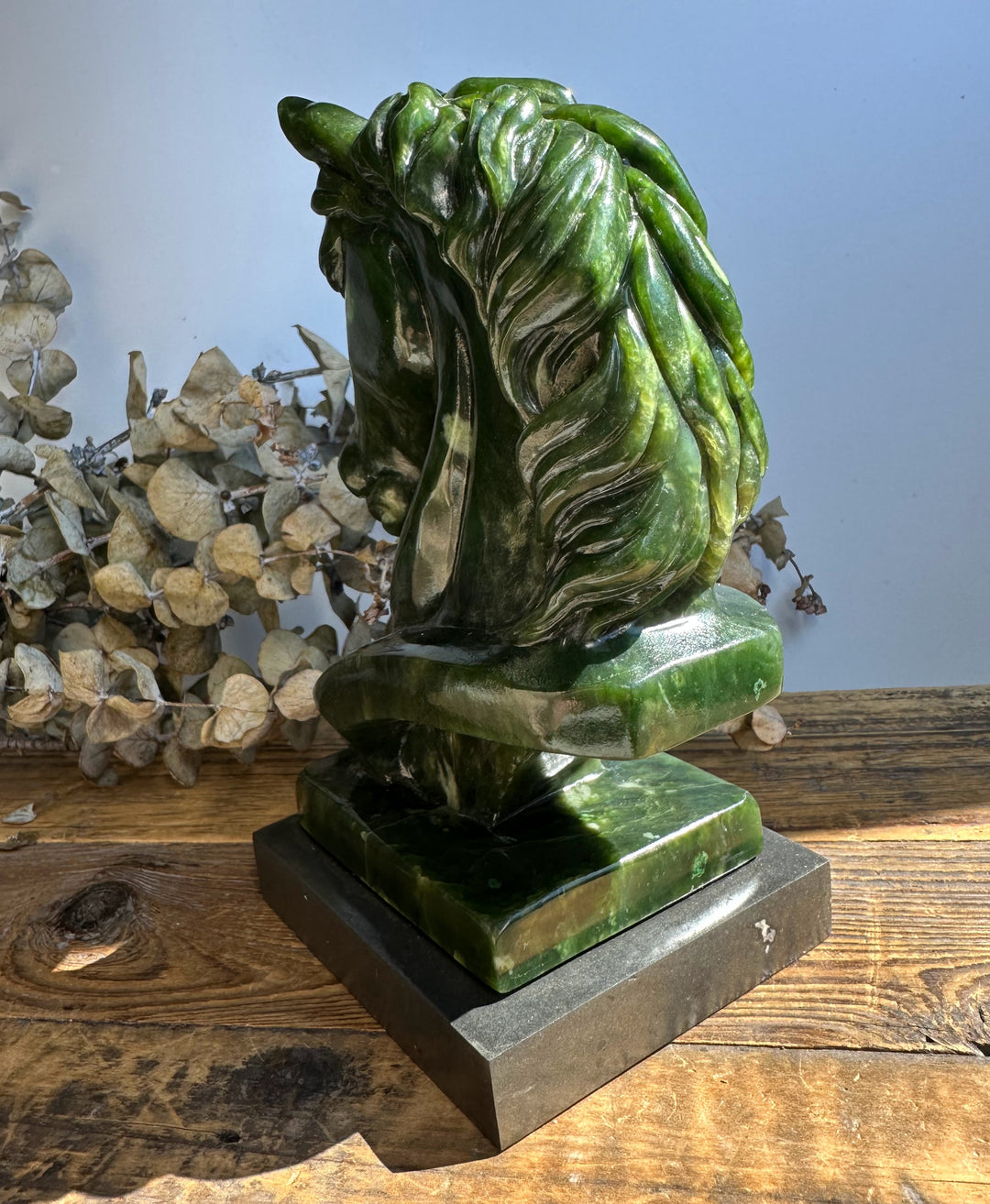 Canadian nephrite jade horse sculpture 6 inches viewed from the rear on a dark base.
