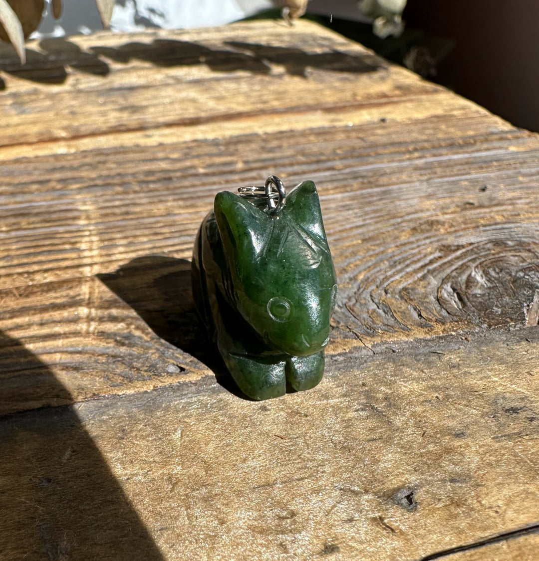 Canadian nephrite jade bunny pendant 1 inch with silver bail on weathered wood.