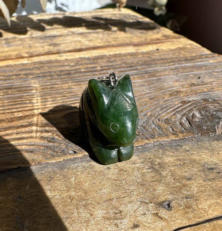 Canadian nephrite jade bunny pendant 1 inch with silver bail on weathered wood.